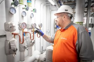 Man in hard hat at controls of Veolia heat network