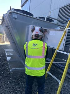 Man in high vis inspecting adiabatic cooler