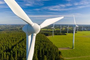 close up of wind turbine, trees and a field